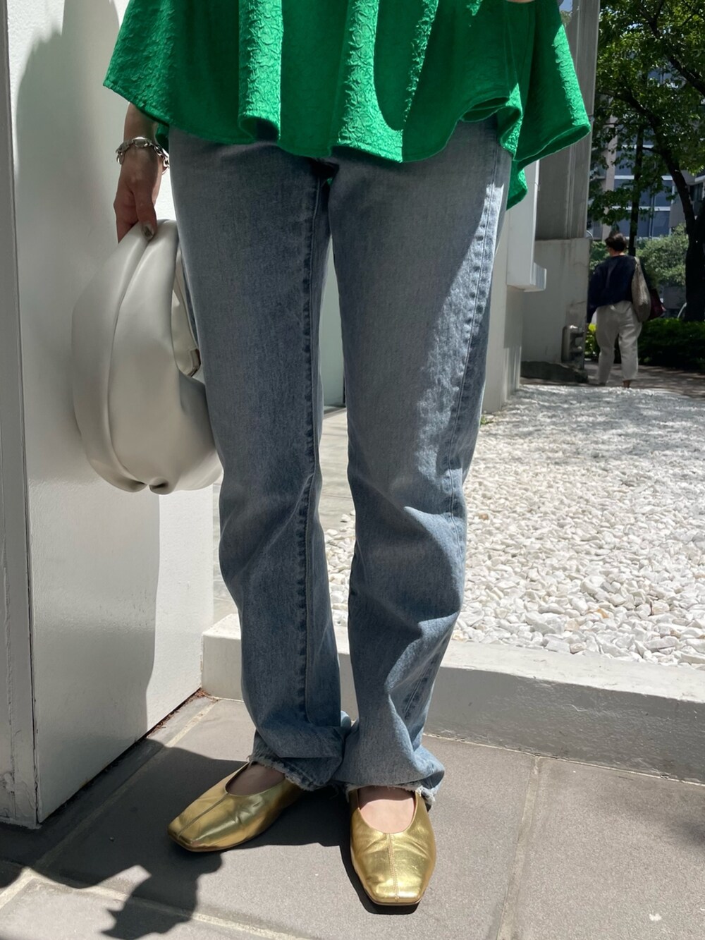 ホワイト系のハンドバッグ、ブルー系のデニムパンツ、グリーン系のシャツ/ブラウスを着用したレディースの春コーディネートの8枚目の写真