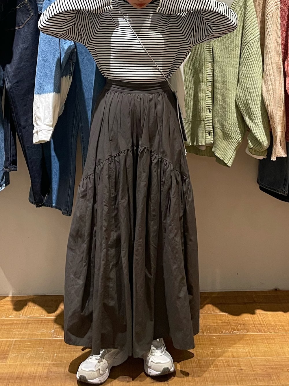 グレー系のスカート、ホワイト系のニット/セーター、シルバー系のショルダーバッグを着用したレディースの冬コーディネートの4枚目の写真