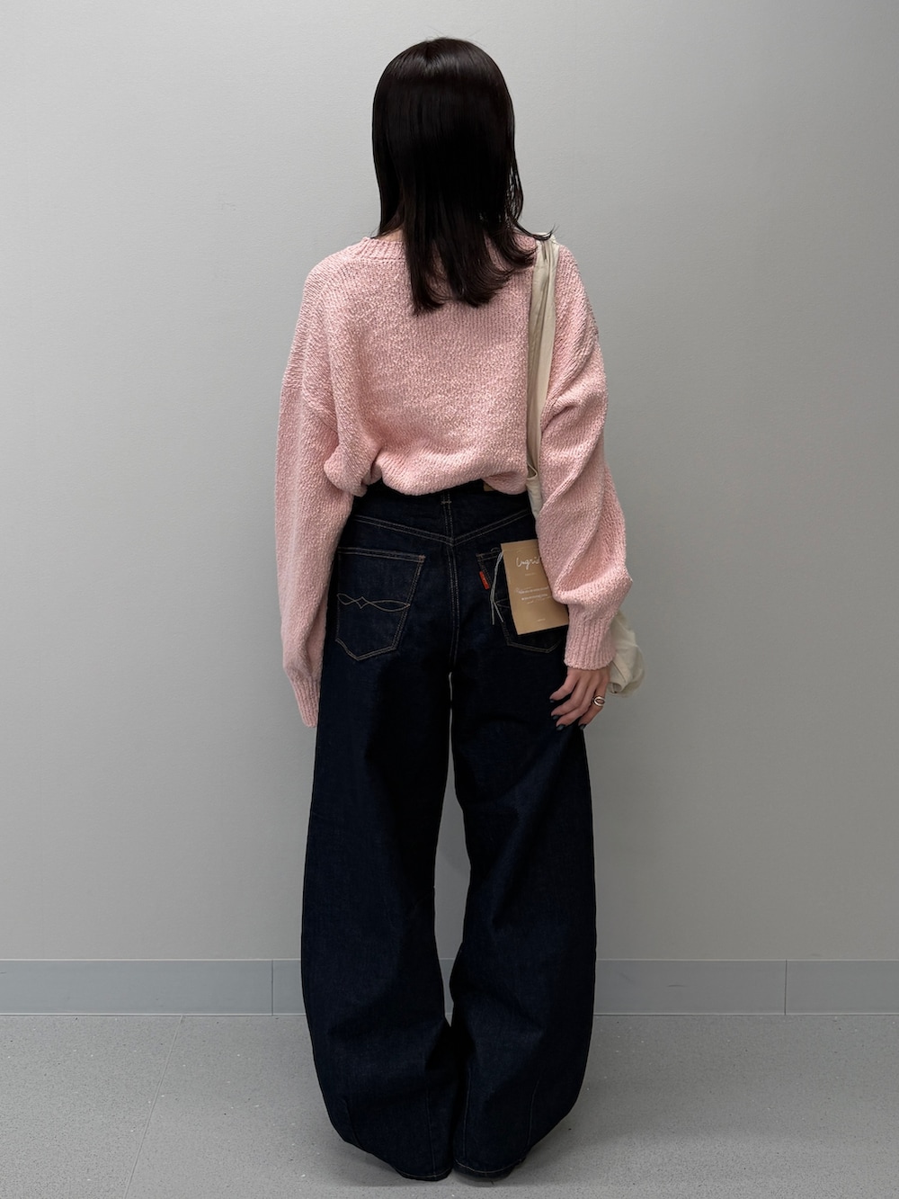 ブルー系のデニムパンツ、ブラック系のブーツ、ピンク系のニット/セーターを着用したレディースの冬コーディネートの3枚目の写真