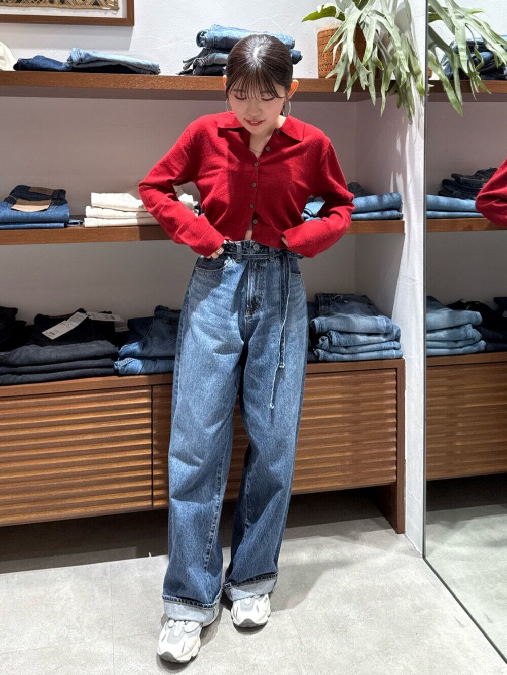 レッド系のカーディガン/ボレロ、ブルー系のデニムパンツを着用したレディースの秋コーディネートの2枚目の写真