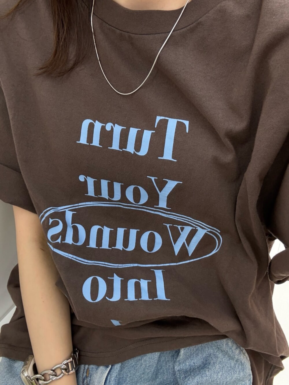ブラック系のサンダル、ブルー系のデニムパンツ、ブラウン系のTシャツ/カットソーを着用したレディースの夏コーディネートの7枚目の写真