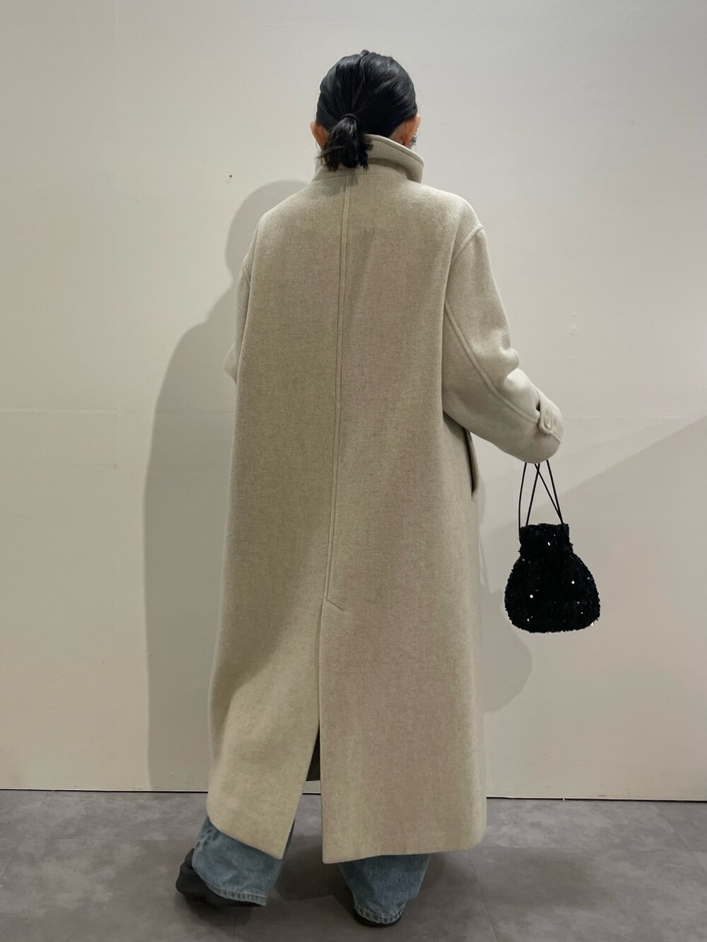 ブルー系のデニムパンツ、ブラック系のブーツ、レッド系のニット/セーターを着用したレディースの冬コーディネートの4枚目の写真