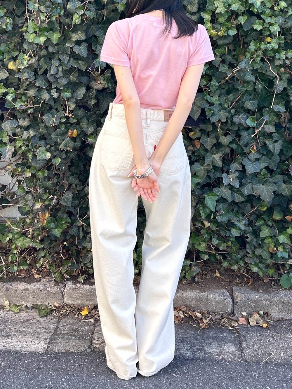 ピンク系のTシャツ/カットソー、ホワイト系のデニムパンツ、ホワイト系のサンダルを着用したレディースの春コーディネートの8枚目の写真