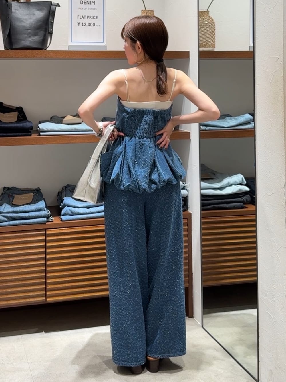 ブルー系のチューブトップ、ブルー系のデニムパンツ、その他のサンダルを着用したレディースの春コーディネートの3枚目の写真