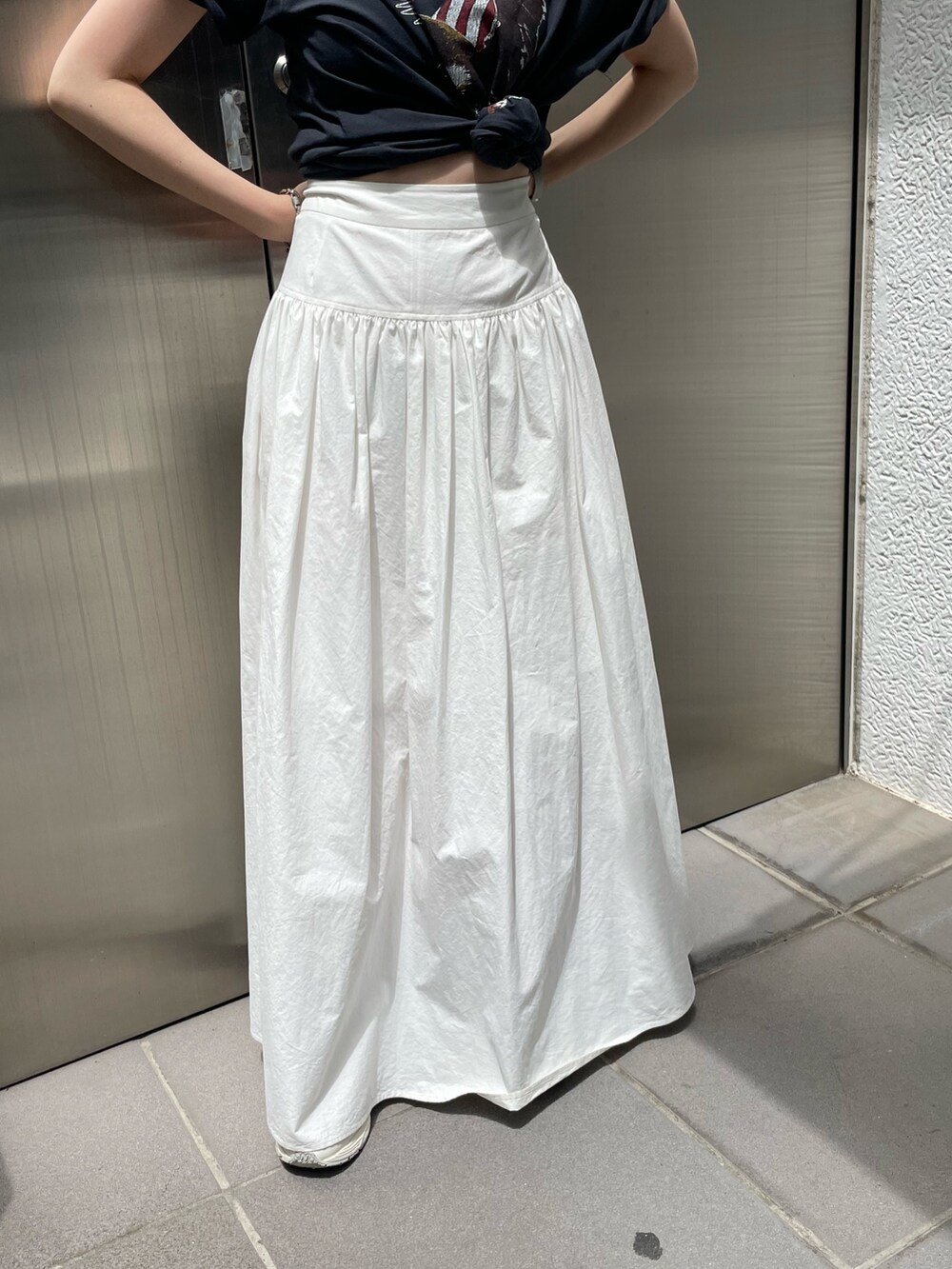 ホワイト系のスカート、グレー系のTシャツ/カットソー、ゴールド系のネックレスを着用したレディースの春コーディネートの6枚目の写真