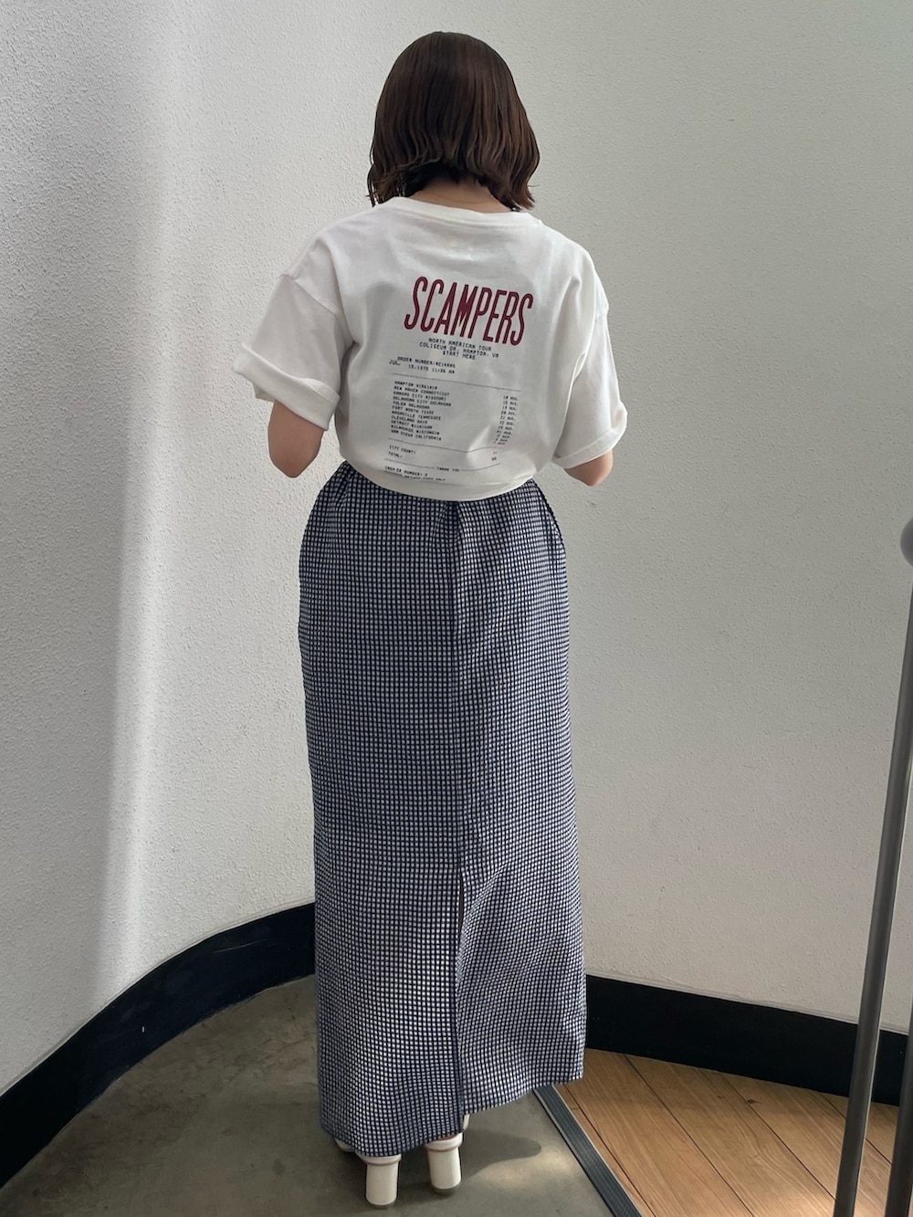 ブルー系のワンピース、ホワイト系のTシャツ/カットソー、ホワイト系のサンダルを着用したレディースの春コーディネートの2枚目の写真