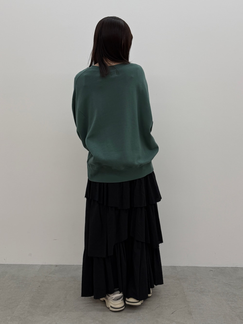 ブラック系のスカート、グリーン系のスウェットを着用したレディースの冬コーディネートの3枚目の写真