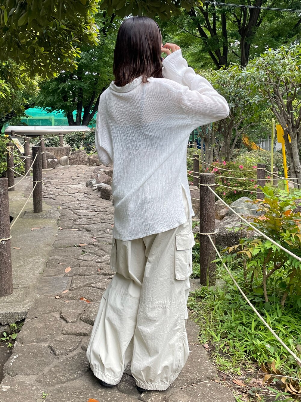 ブラック系のキャミソール、ホワイト系のシャツ/ブラウス、ホワイト系のカーゴパンツを着用したレディースの夏コーディネートの7枚目の写真