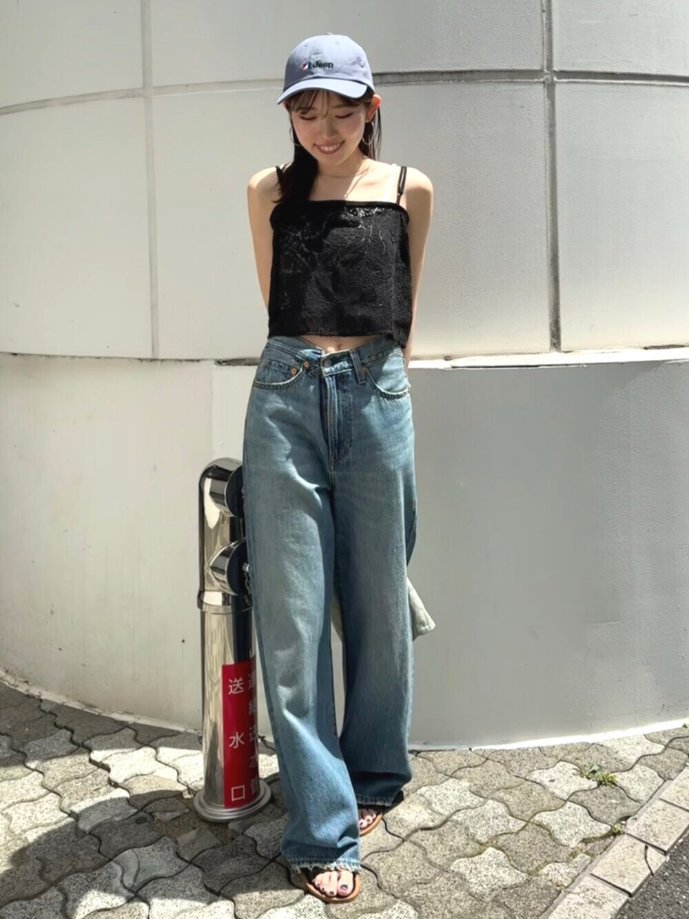 ブラック系のサンダル、グリーン系のトートバッグ、ブルー系のデニムパンツを着用したレディースの夏コーディネートの6枚目の写真