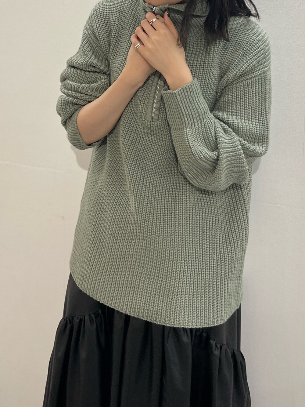 ブラック系のブーツ、ブラック系のスカート、グレー系のニット/セーターを着用したレディースの冬コーディネートの6枚目の写真