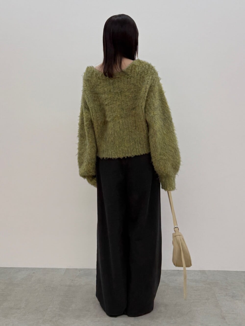 ベージュ系のハンドバッグ、ブラウン系のその他パンツ、イエロー系のニット/セーターを着用したレディースの秋コーディネートの4枚目の写真