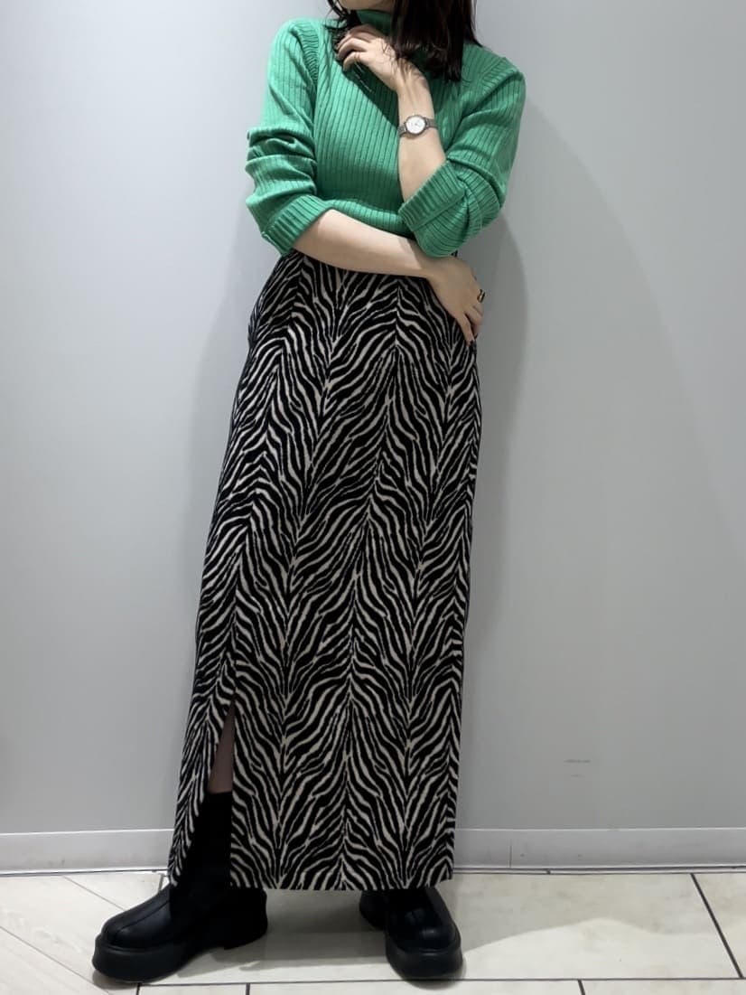 ホワイト系のハンドバッグ、グリーン系のニット/セーター、ブラック系のスカートを着用したレディースの秋コーディネートの3枚目の写真