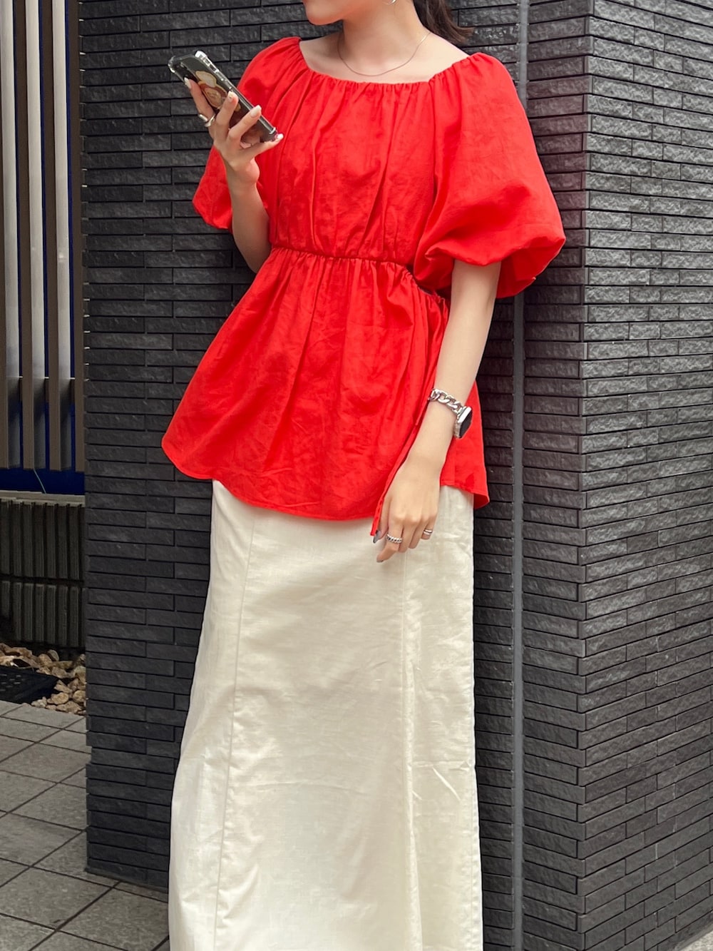 グレー系のキャミソール、ホワイト系のスカート、ホワイト系のサンダルを着用したレディースの春コーディネートの6枚目の写真