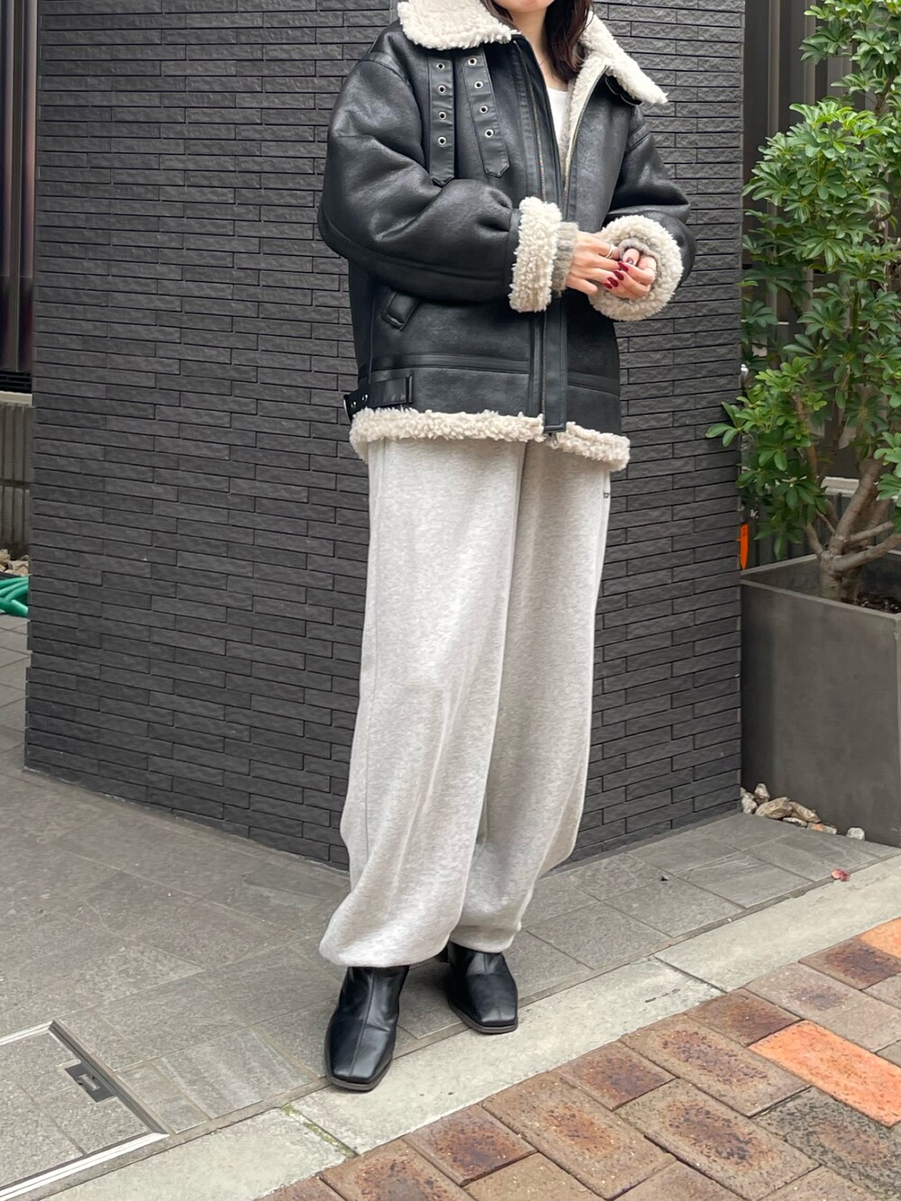 グレー系のスウェットパンツ、ブラック系のブーツ、グレー系のカーディガン/ボレロを着用したレディースの冬コーディネートの7枚目の写真