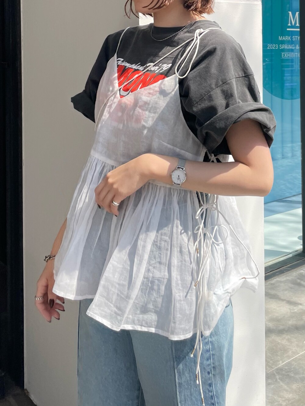 ブルー系のデニムパンツ、グレー系のTシャツ/カットソー、ホワイト系のショルダーバッグを着用したレディースの春コーディネートの5枚目の写真
