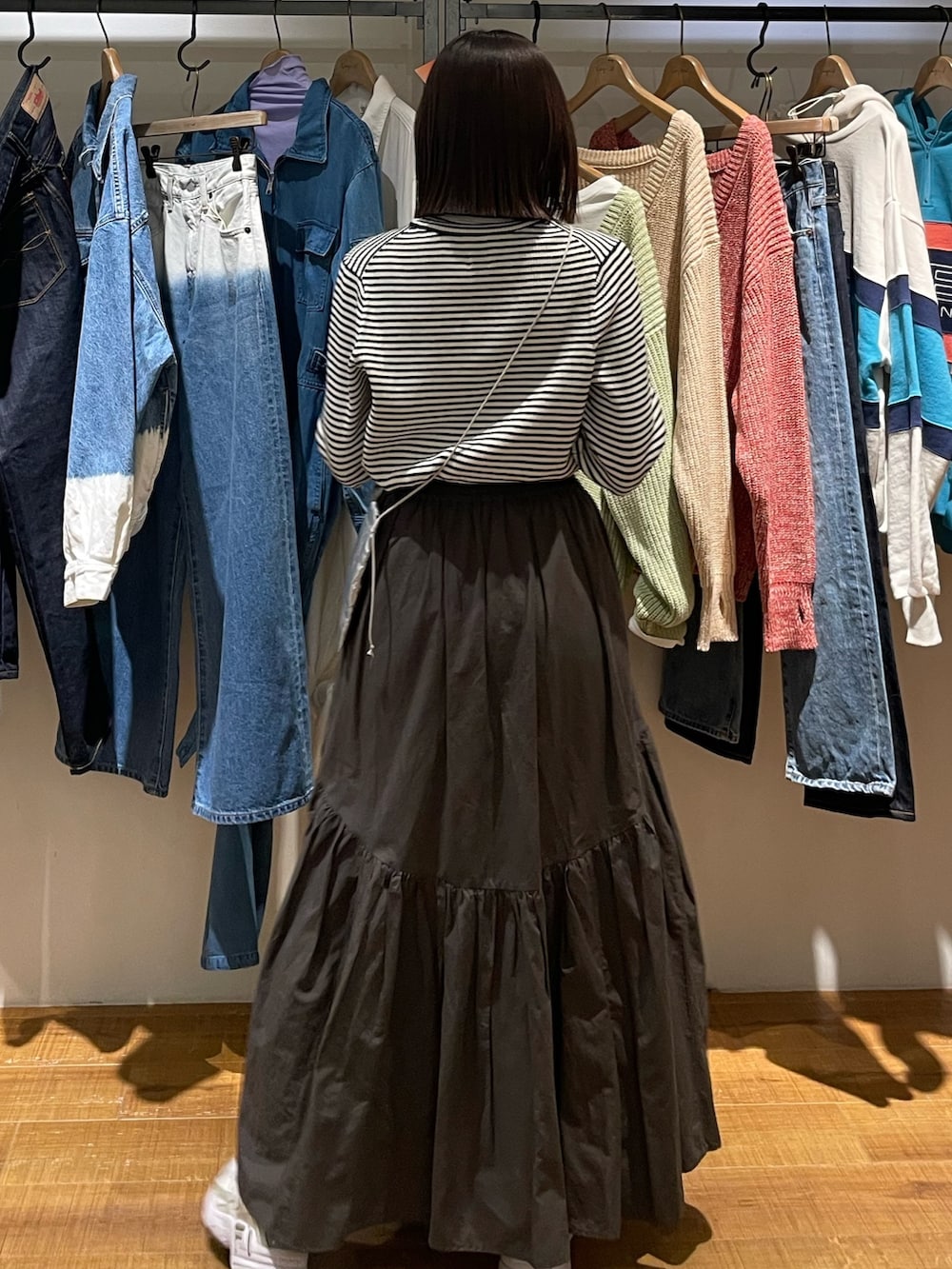 グレー系のスカート、ホワイト系のニット/セーター、シルバー系のショルダーバッグを着用したレディースの冬コーディネートの7枚目の写真