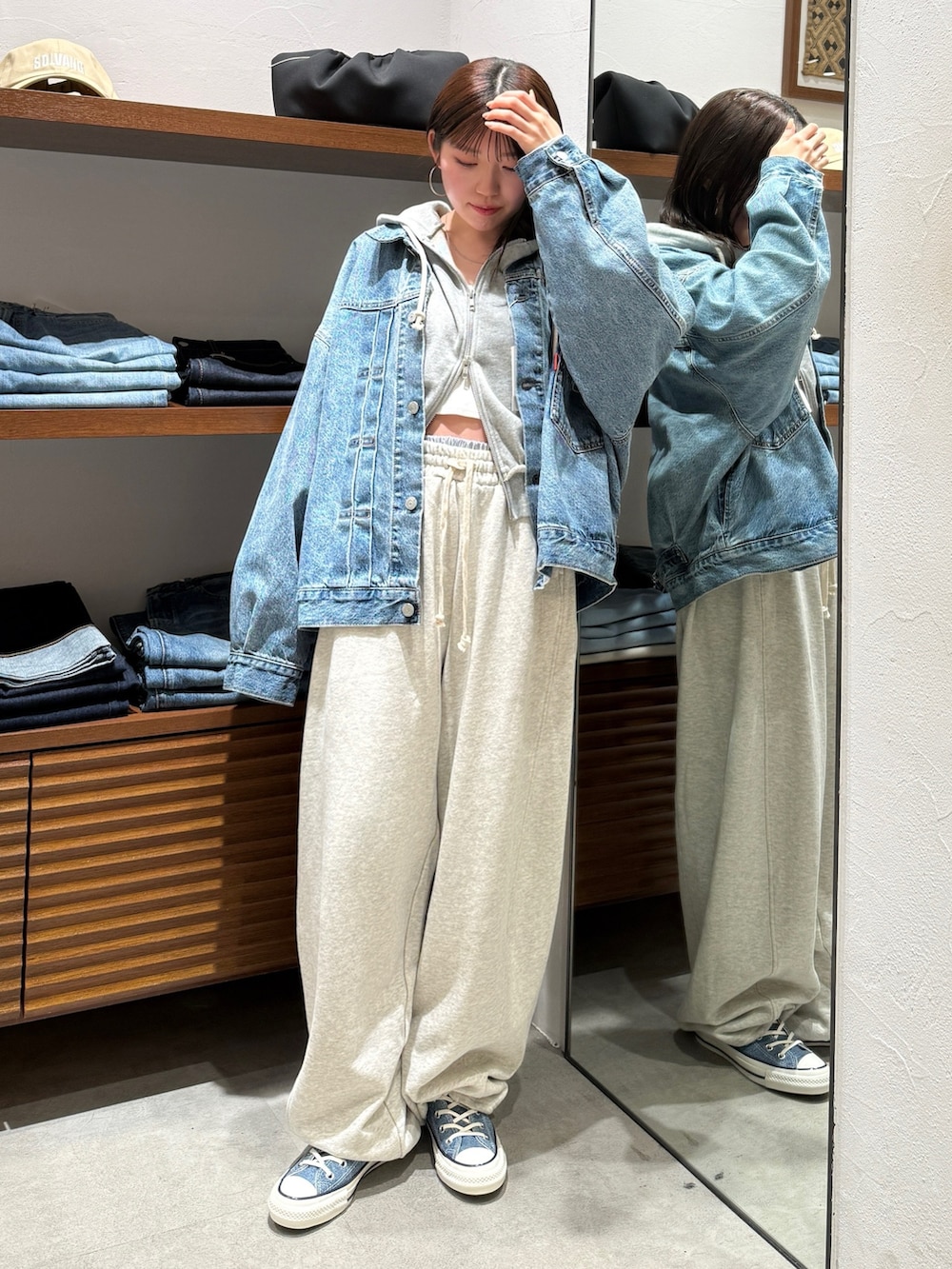 ホワイト系のスウェットパンツ、ブルー系のスニーカー、ブルー系のデニムジャケットを着用したレディースの春コーディネートの2枚目の写真