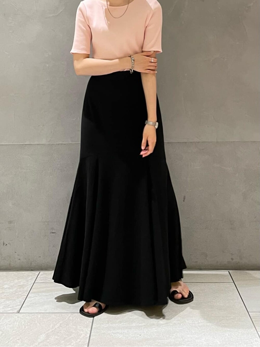 ブラック系のサンダル、ブラック系のスカート、ピンク系のTシャツ/カットソーを着用したレディースの夏コーディネートの2枚目の写真