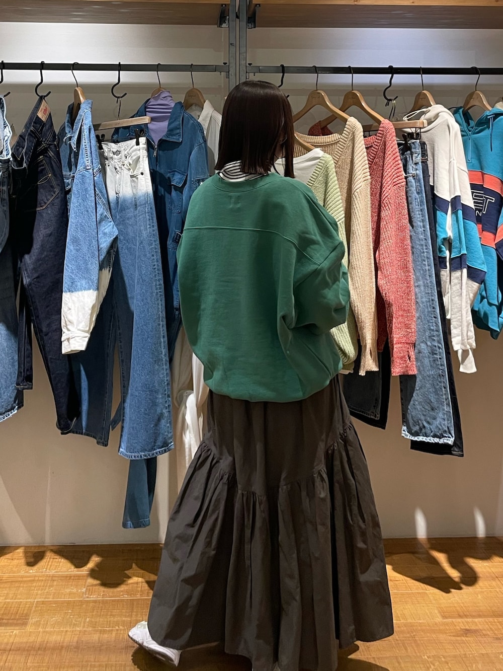 グレー系のスカート、グリーン系のスウェット、ホワイト系のニット/セーターを着用したレディースの冬コーディネートの4枚目の写真