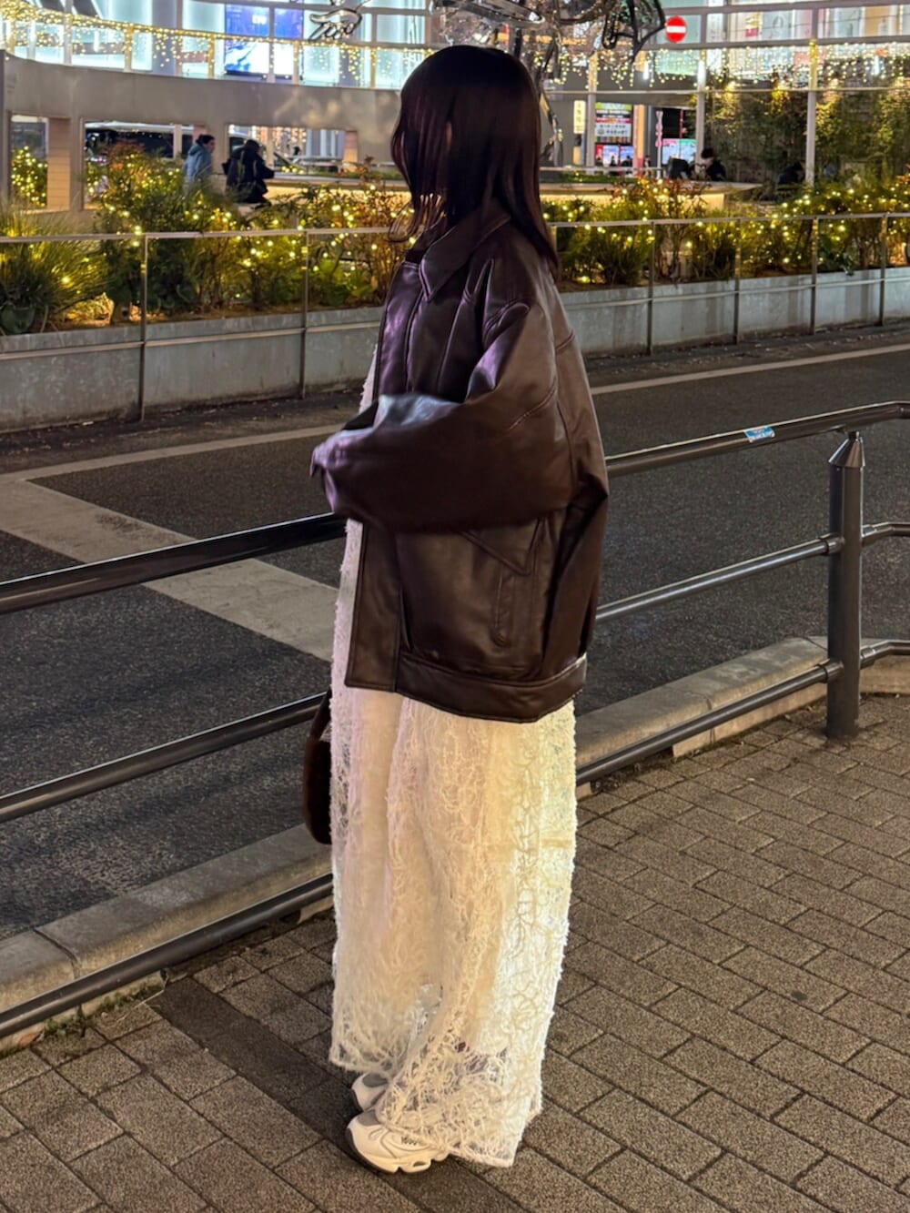 ブラウン系のハンドバッグ、ホワイト系のワンピース、ブラウン系のブルゾンを着用したレディースの冬コーディネートの3枚目の写真