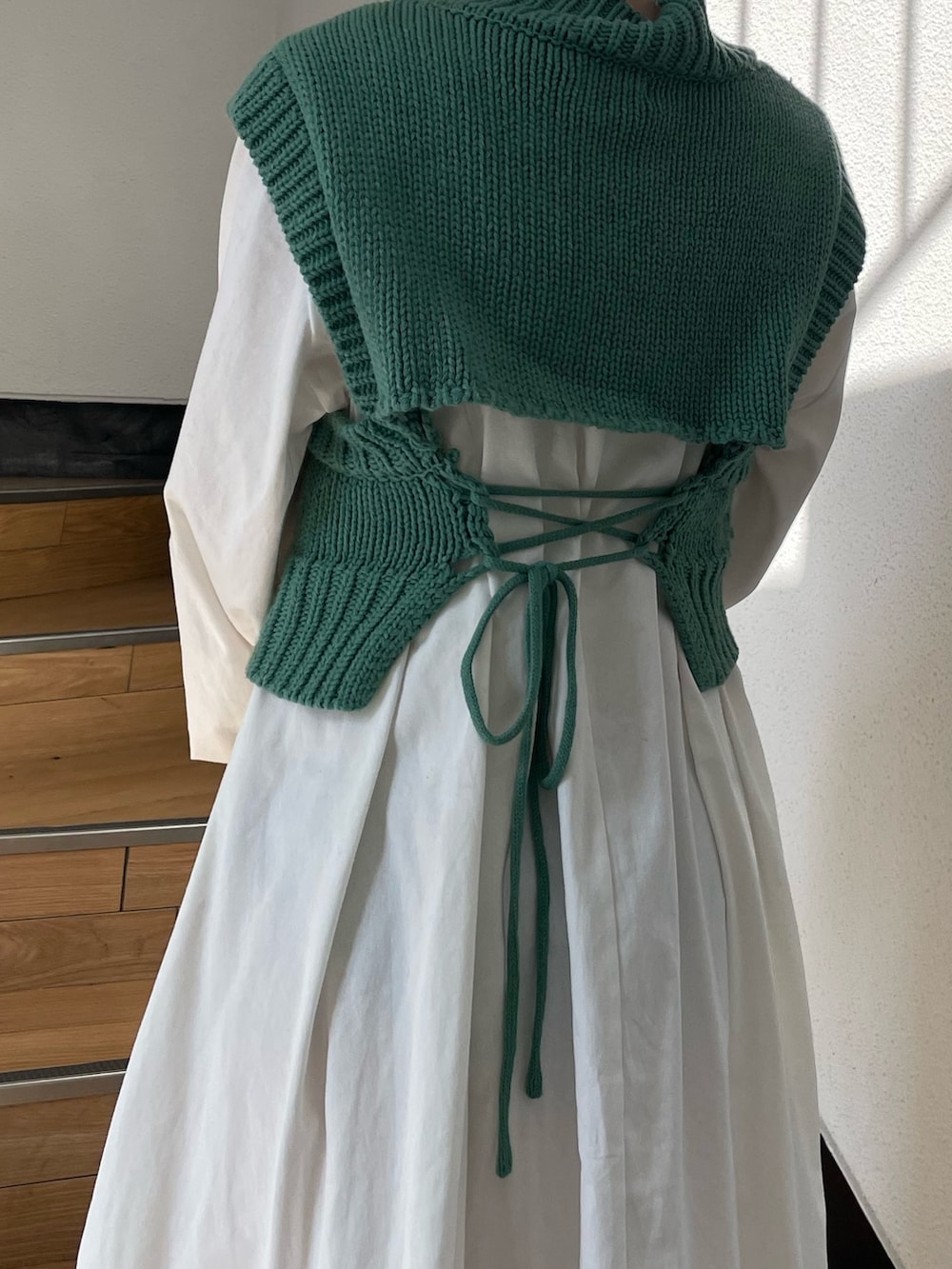 グリーン系のワンピース、ホワイト系のキャップを着用したレディースの春コーディネートの4枚目の写真