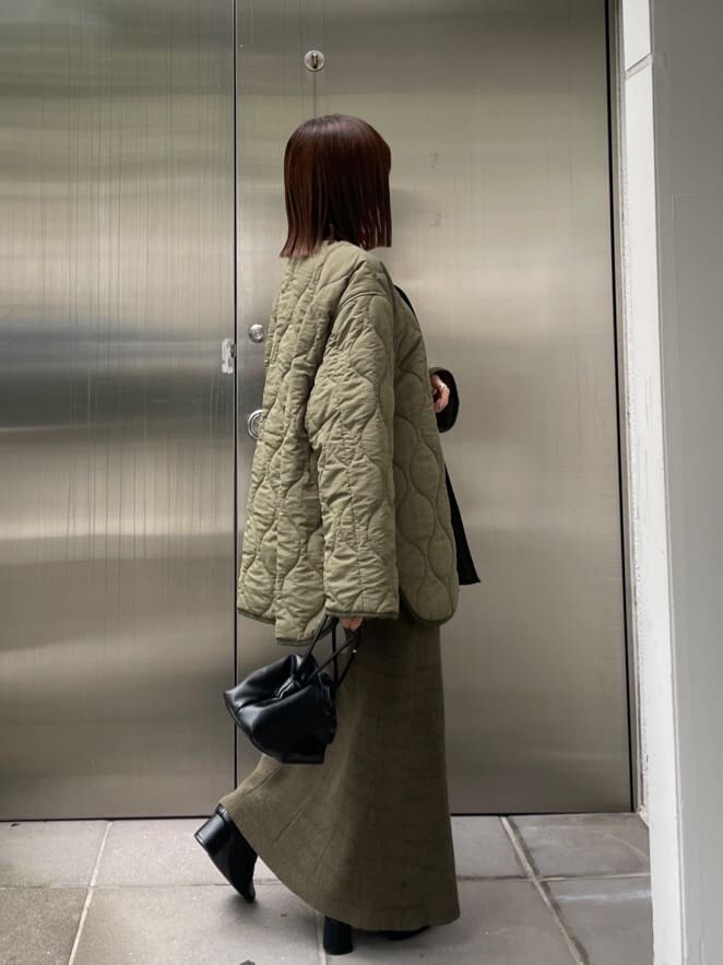 ブラック系のブーツ、グリーン系のブルゾン、レッド系のニット/セーターを着用したレディースの秋コーディネートの7枚目の写真