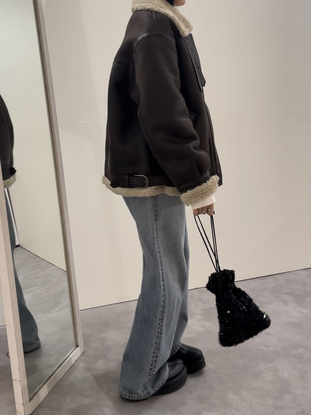 ブルー系のデニムパンツ、ブラック系のブーツ、ピンク系のニット/セーターを着用したレディースの冬コーディネートの3枚目の写真