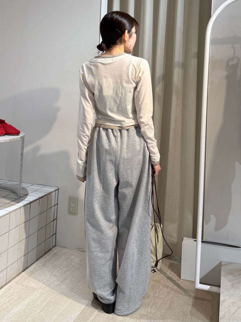 グレー系のスウェットパンツ、ブラック系のサンダル、ホワイト系のカーディガン/ボレロを着用したレディースの冬コーディネートの2枚目の写真