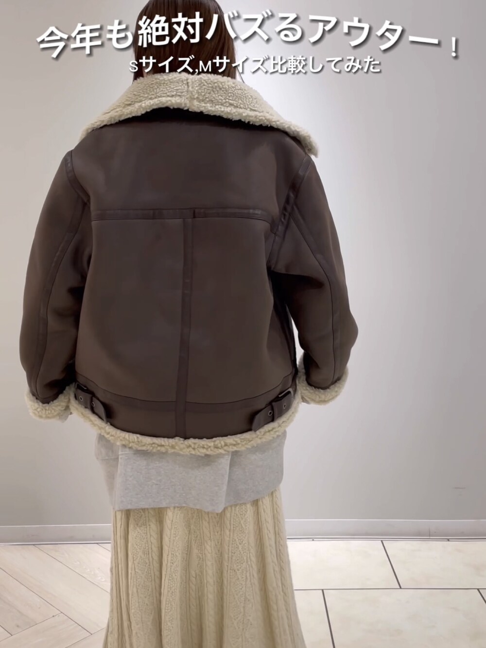 ブラウン系のムートンコート、グレー系のスウェット、ホワイト系のスカートを着用したレディースの秋コーディネートの4枚目の写真