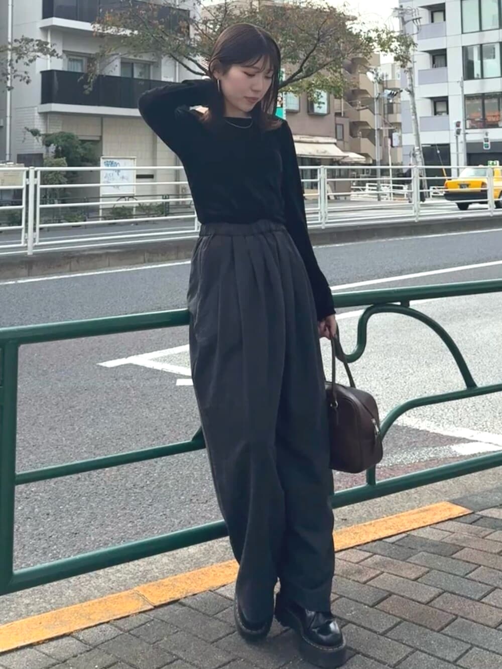 ブラウン系のハンドバッグ、グレー系のその他パンツ、ブラック系のTシャツ/カットソーを着用したレディースの秋コーディネートの4枚目の写真