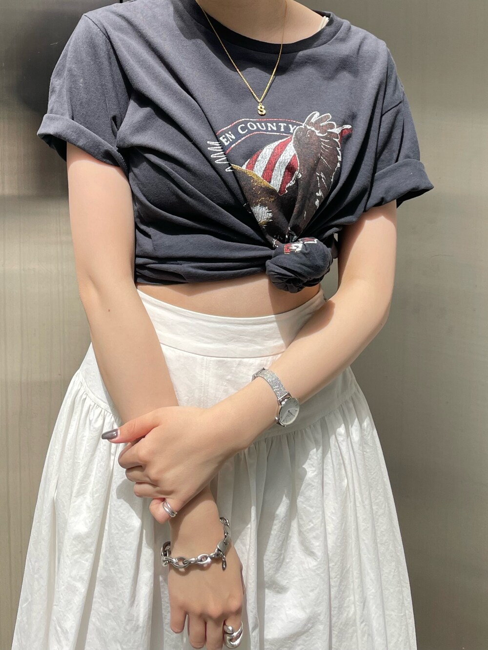 ホワイト系のスカート、グレー系のTシャツ/カットソー、ゴールド系のネックレスを着用したレディースの春コーディネートの5枚目の写真