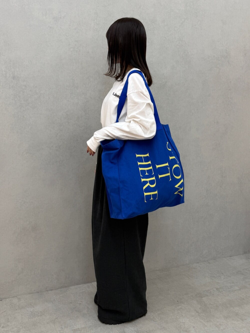 グレー系のその他パンツ、ブルー系のトートバッグ、ホワイト系のTシャツ/カットソーを着用したレディースの秋コーディネートの2枚目の写真