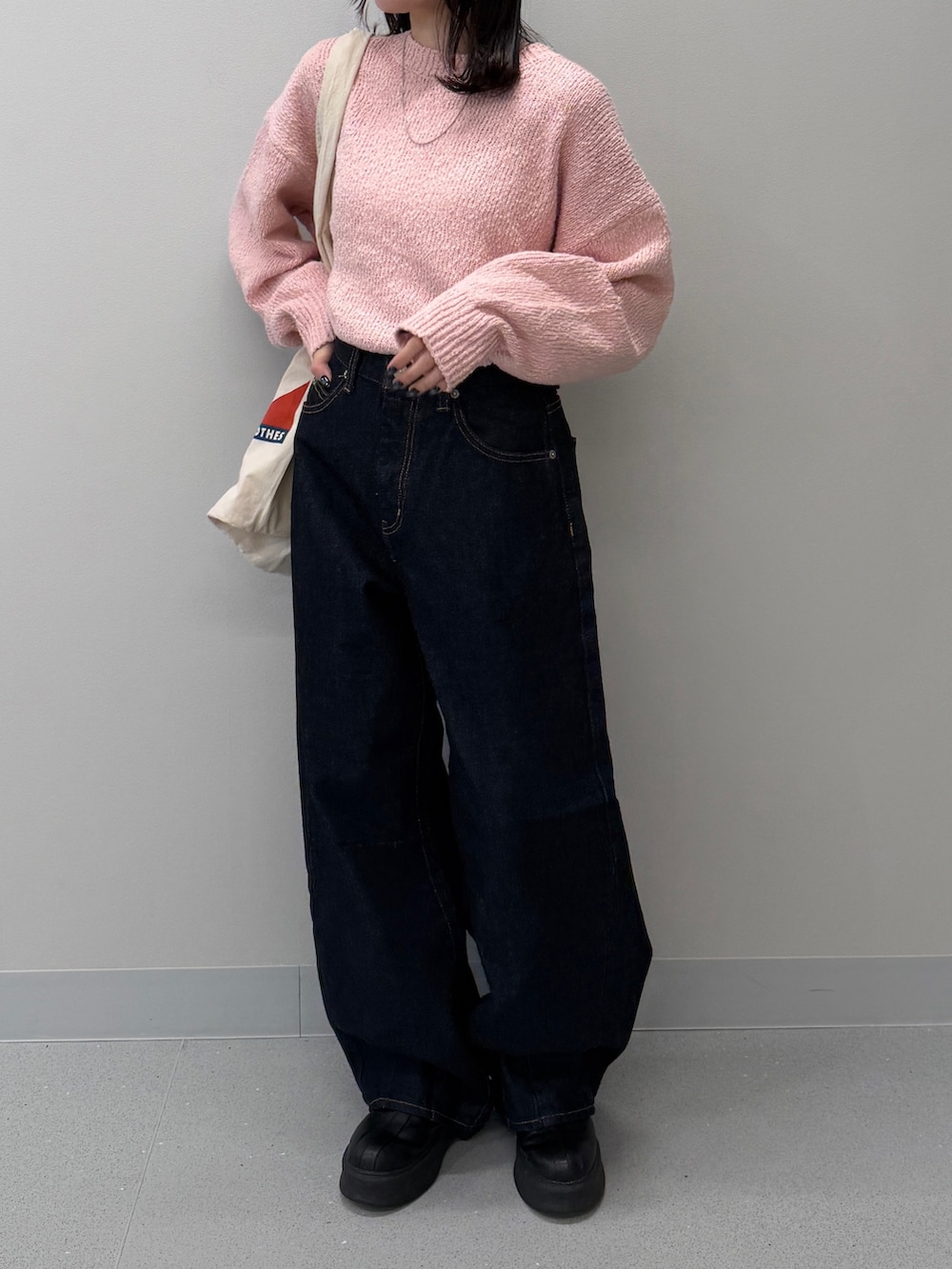 ブルー系のデニムパンツ、ブラック系のブーツ、ピンク系のニット/セーターを着用したレディースの冬コーディネートの6枚目の写真