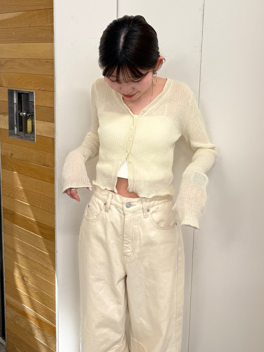 ホワイト系のデニムパンツ、ベージュ系のブーツ、ホワイト系のカーディガン/ボレロを着用したレディースの春コーディネートの8枚目の写真