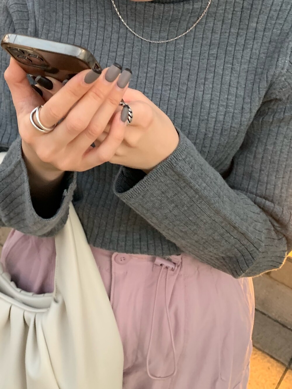 ピンク系のカーゴパンツ、ホワイト系のハンドバッグ、ホワイト系のダッフルコートを着用したレディースの冬コーディネートの6枚目の写真