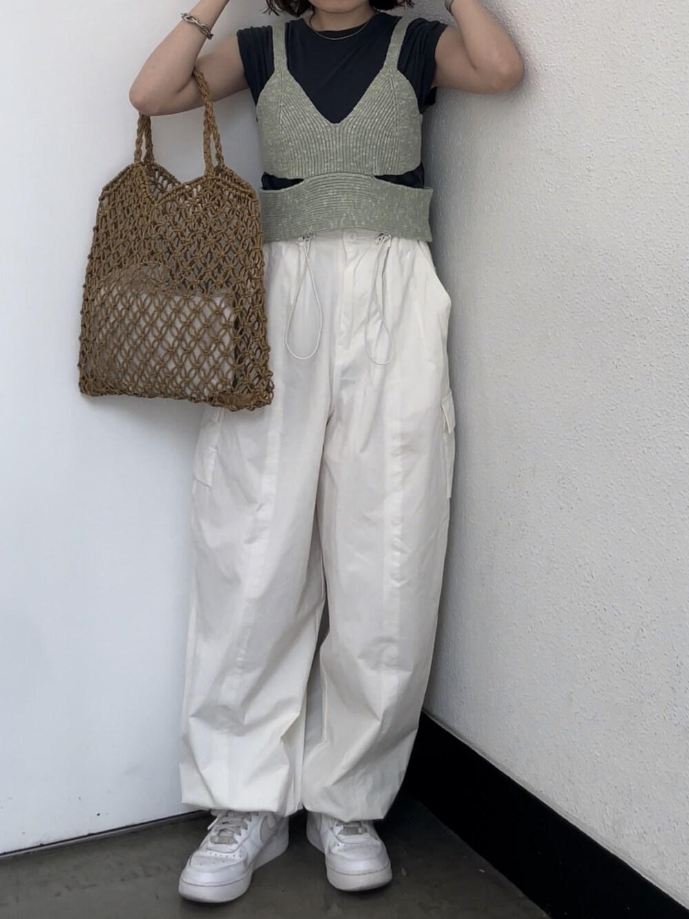 ホワイト系のカーゴパンツ、グリーン系のニット/セーター、グレー系のタンクトップを着用したレディースの春コーディネートの2枚目の写真