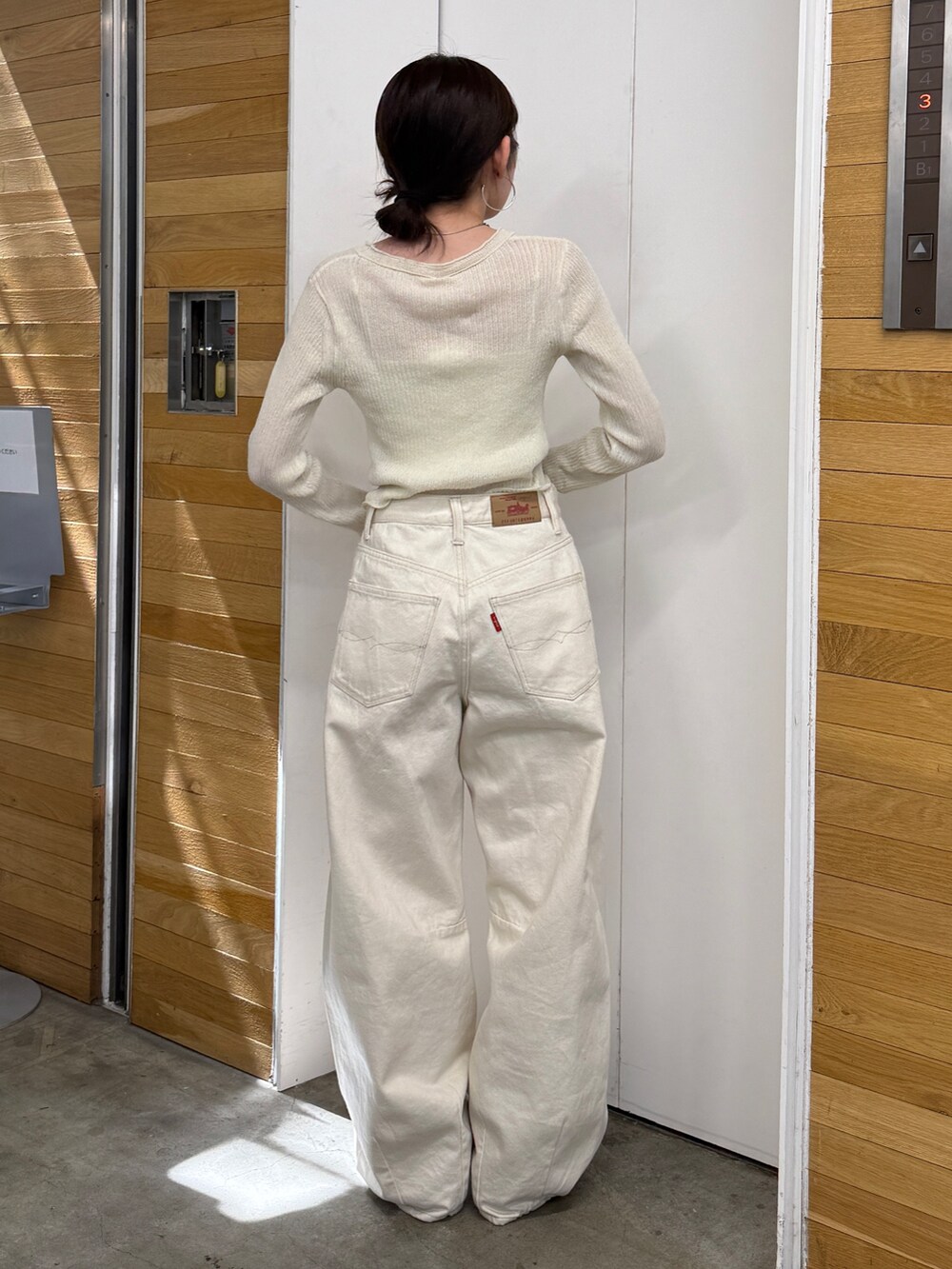 ホワイト系のデニムパンツ、ベージュ系のブーツ、ホワイト系のカーディガン/ボレロを着用したレディースの春コーディネートの5枚目の写真