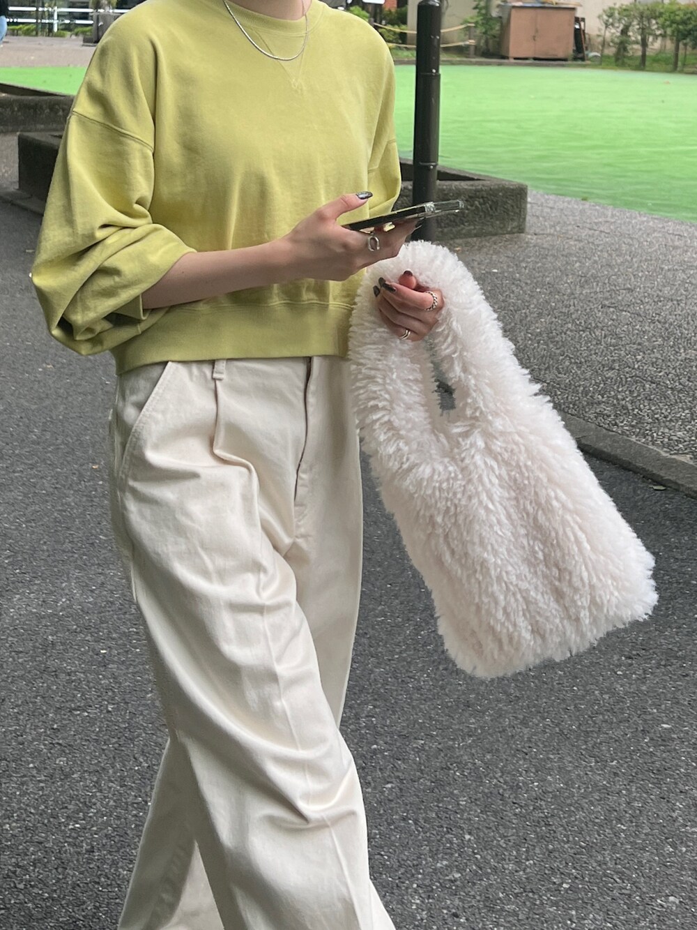 ホワイト系のデニムパンツ、ブラウン系のブーツ、グリーン系のスウェットを着用したレディースの秋コーディネートの6枚目の写真