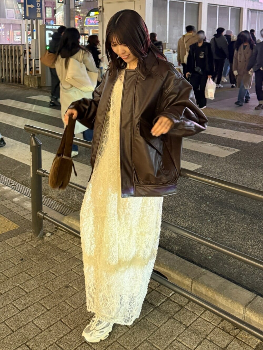 ブラウン系のハンドバッグ、ホワイト系のワンピース、ブラウン系のブルゾンを着用したレディースの冬コーディネートの2枚目の写真