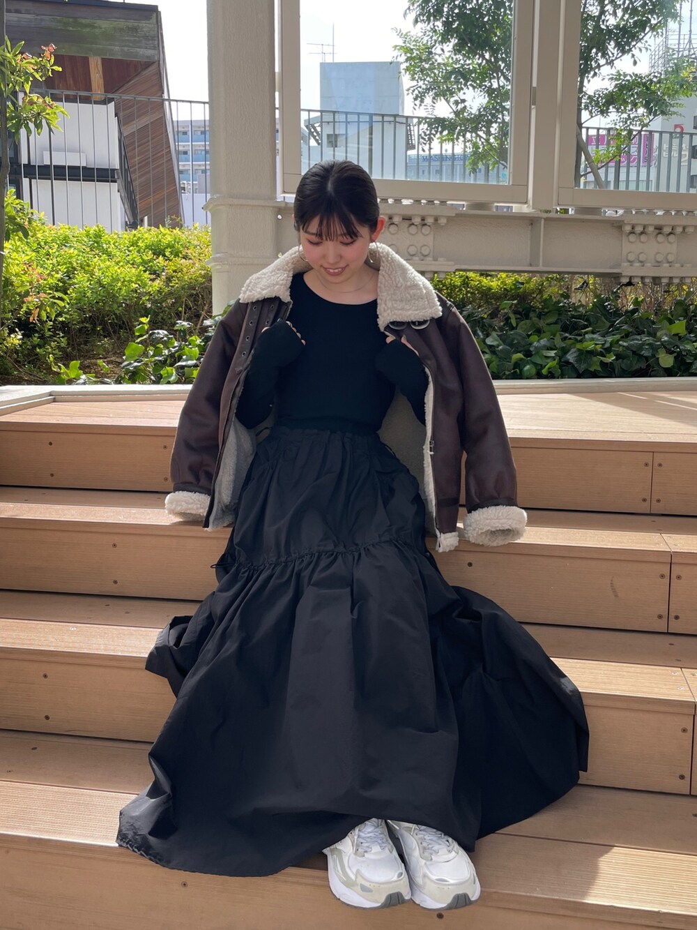 ブラック系のワンピース、ブラウン系のムートンコートを着用したレディースの秋コーディネートの2枚目の写真