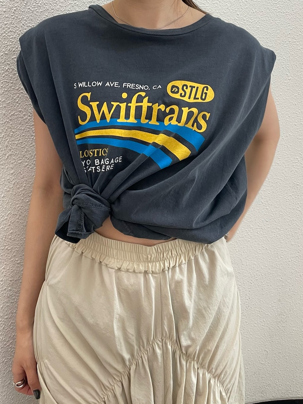 ホワイト系のスカート、グレー系のTシャツ/カットソーを着用したレディースの夏コーディネートの7枚目の写真