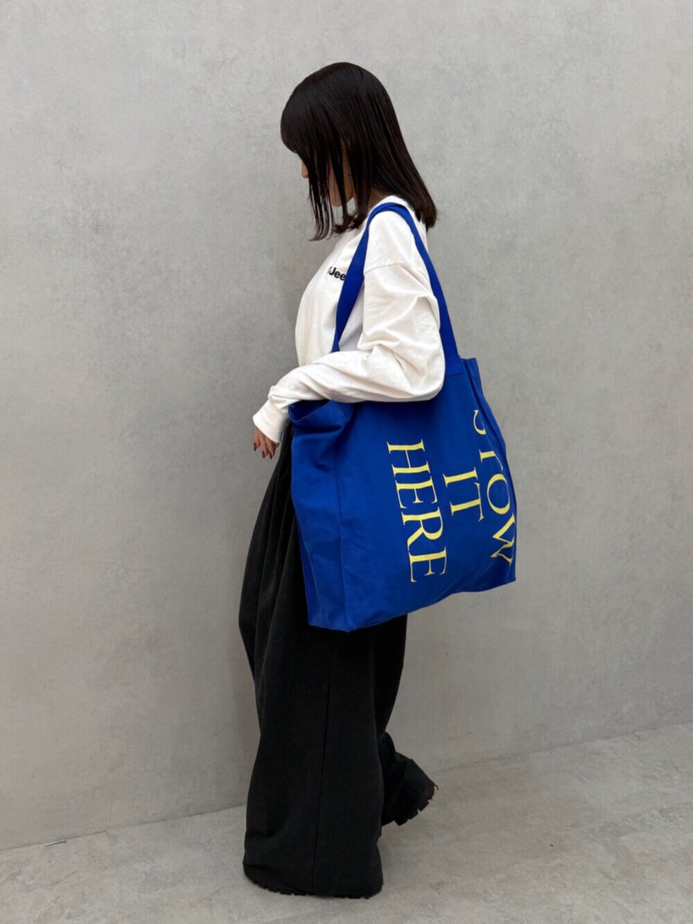 グレー系のその他パンツ、ブルー系のトートバッグ、ホワイト系のTシャツ/カットソーを着用したレディースの秋コーディネートの3枚目の写真