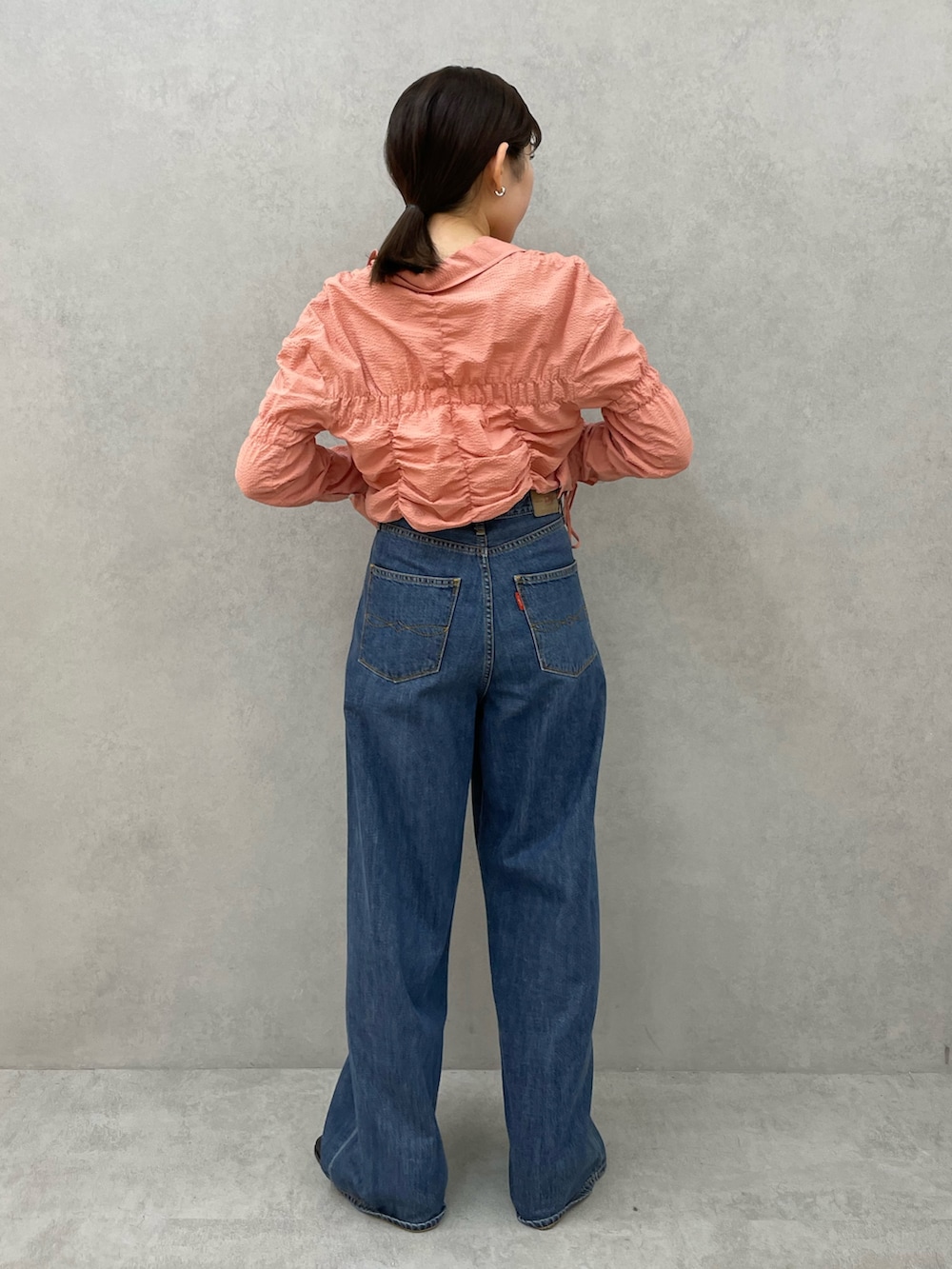 ブラック系のブーツ、ブルー系のデニムパンツ、ピンク系のシャツ/ブラウスを着用したレディースの秋コーディネートの4枚目の写真