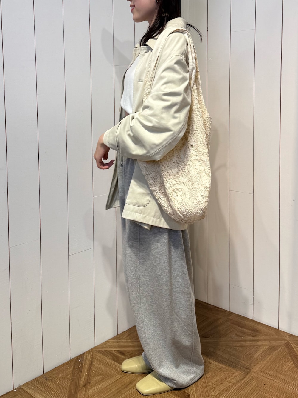 グレー系のスウェットパンツ、イエロー系のサンダル、ホワイト系のテーラードジャケットを着用したレディースの春コーディネートの3枚目の写真