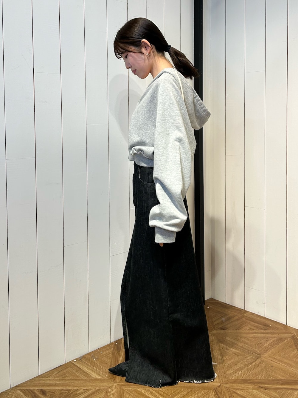 ブラック系のパンプス、ブラック系のスカート、グレー系のパーカーを着用したレディースの春コーディネートの3枚目の写真