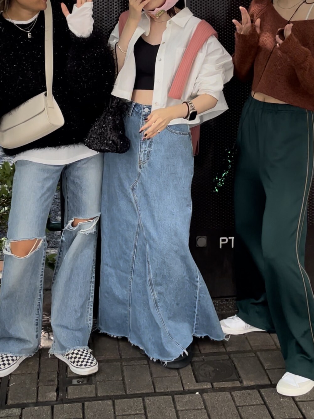 ブラック系のブーツ、ブルー系のデニムスカート、ブラック系のハンドバッグを着用したレディースの秋コーディネートの2枚目の写真