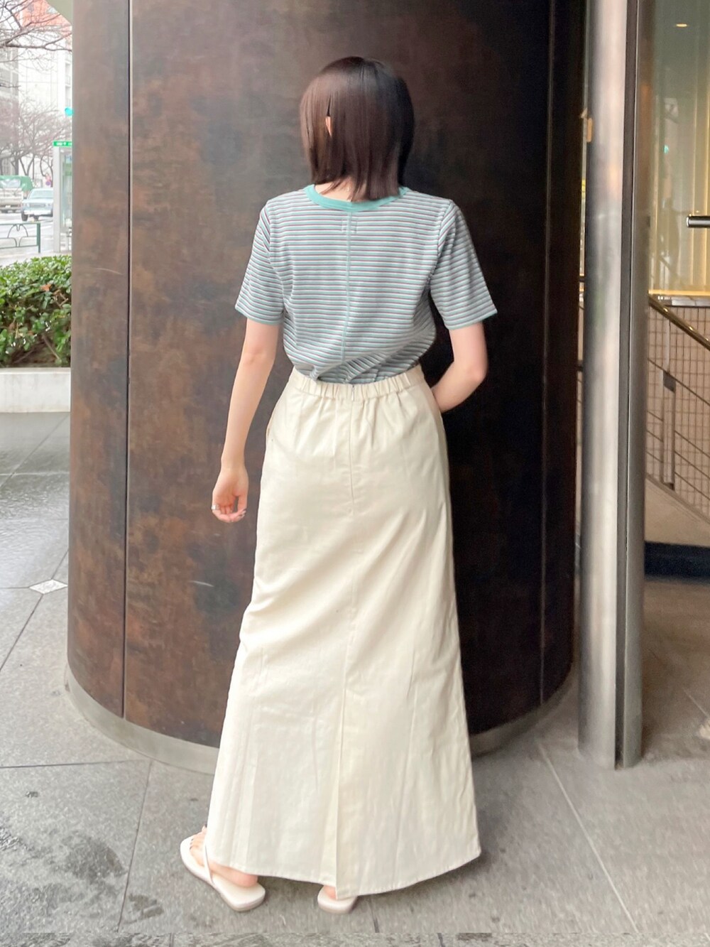 グリーン系のTシャツ/カットソー、ホワイト系のサンダル、ホワイト系のスカートを着用したレディースの春コーディネートの2枚目の写真