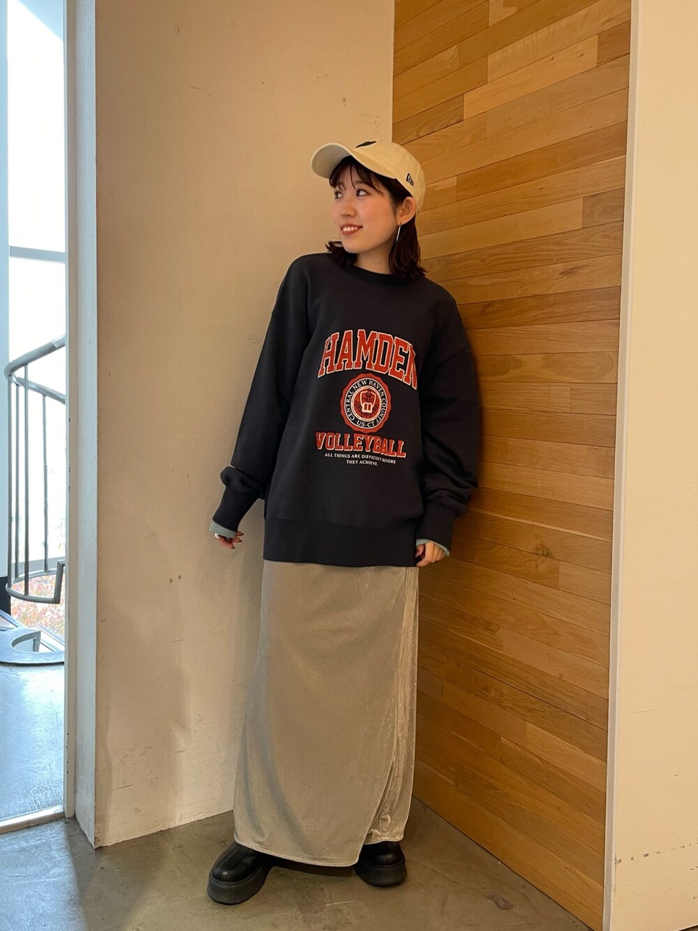 グレー系のスカート、ブラック系のブーツ、ブルー系のTシャツ/カットソーを着用したレディースの秋コーディネートの2枚目の写真