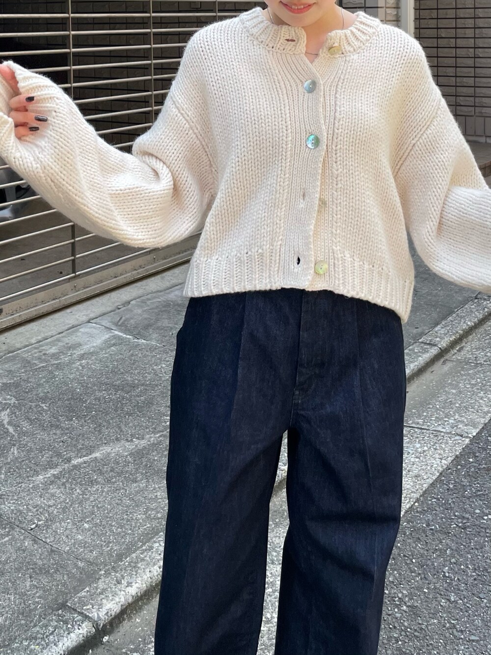 ブラック系のローファー、ブルー系のデニムパンツ、ホワイト系のカーディガン/ボレロを着用したレディースの秋コーディネートの6枚目の写真