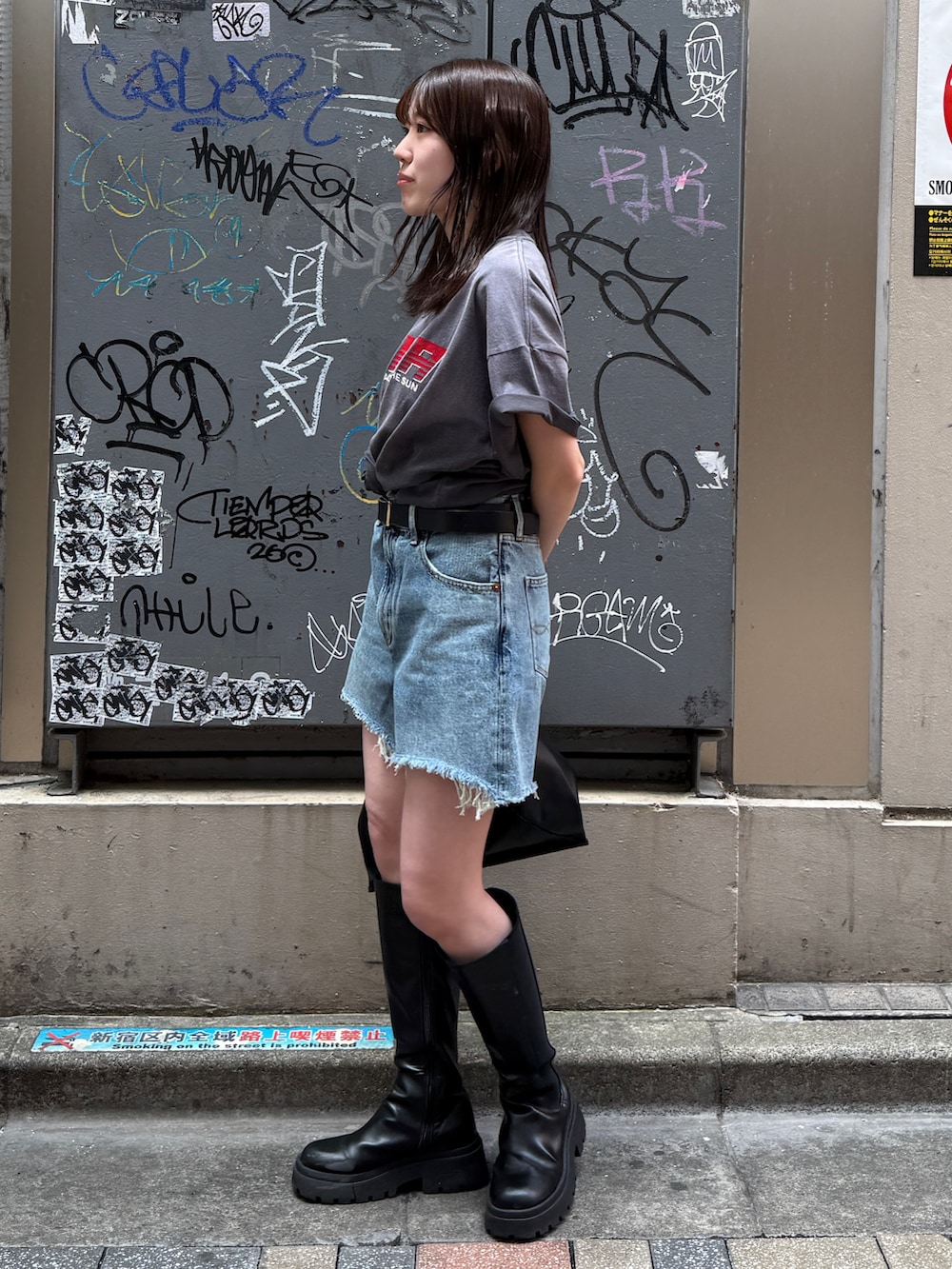 ブルー系のデニムパンツ、グレー系のTシャツ/カットソー、ブラック系のハンドバッグを着用したレディースの春コーディネートの4枚目の写真